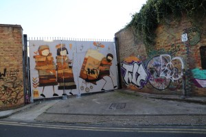 The mural on the doors is legal; the street art on the wall is not.