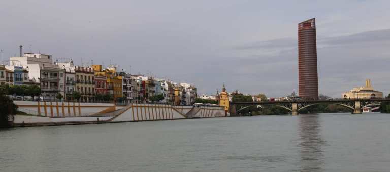 Beautiful, river-side homes and a modern building along the river.